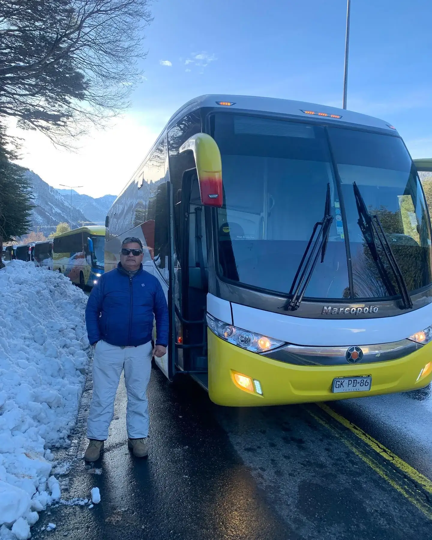 Conductor junto a bus en cordillera